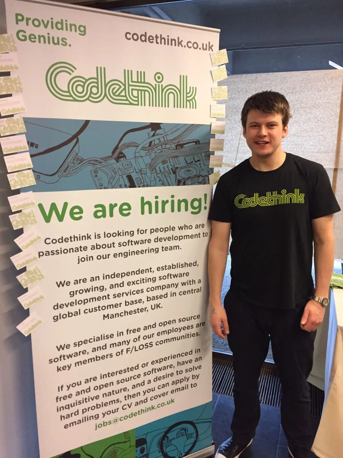 Laurence with Codethink banner at FOSDEM